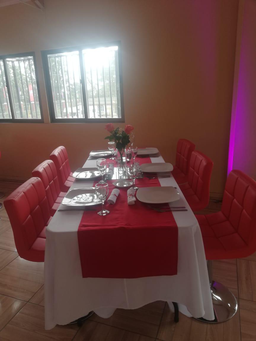 Mesa decorada con sillas rojas para cena de celebración