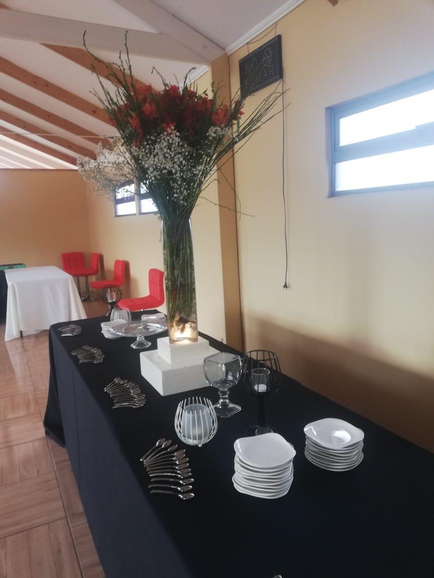 Salón de eventos completo con mesas y sillas rojas