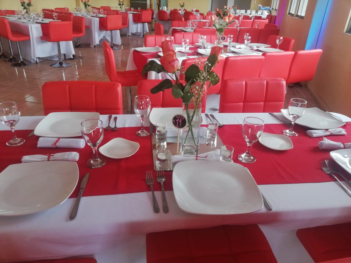Mesa servida con vajilla, copas y flores para celebración